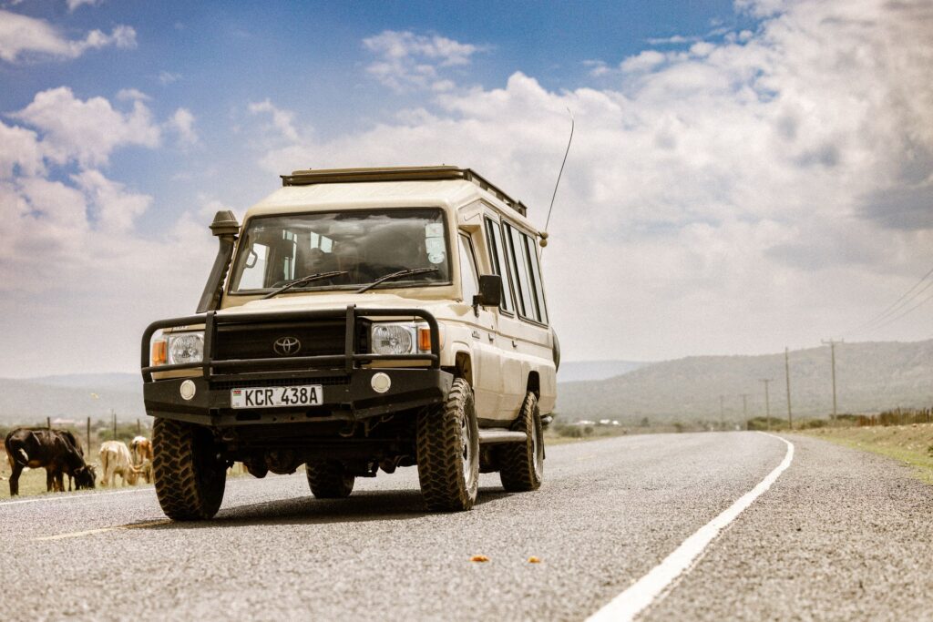 Safari vehicle travelling through rural Kenya